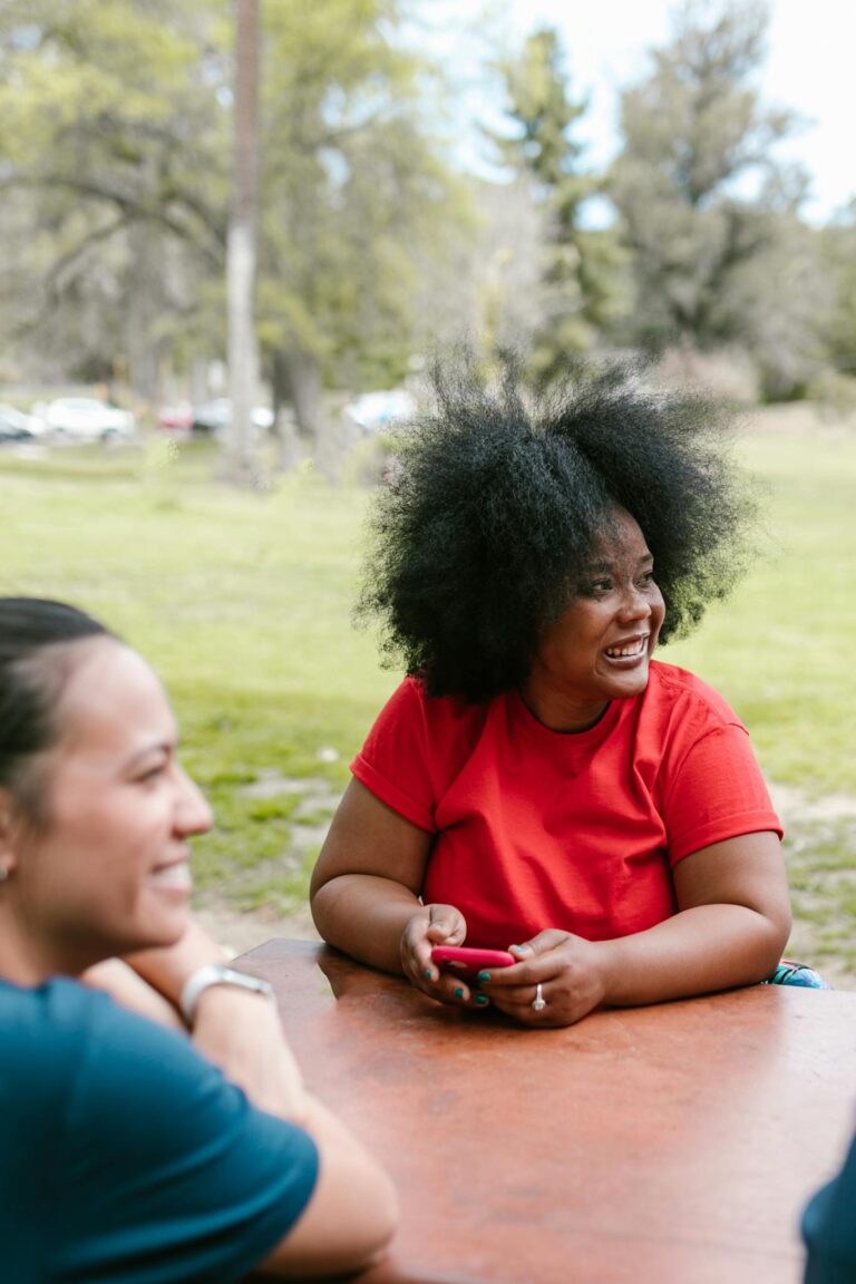 Smiling individuals bonding and enjoying leisure time in a sunny park.